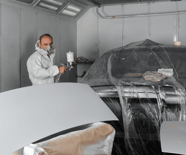 Carrossier peintre réalisant des travaux de peinture sur une Peugeot à Auriac dans le 64